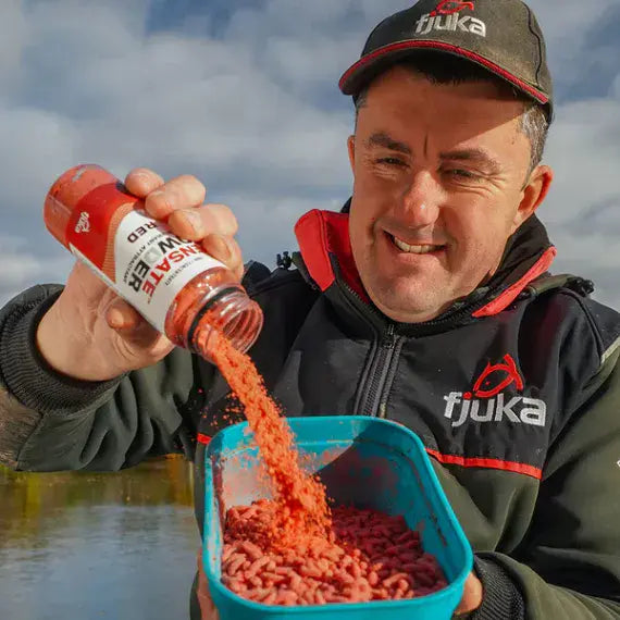 Fjuka Baits fisherman pouring Fjuka Sensate Powder Red bait additive on to pellets