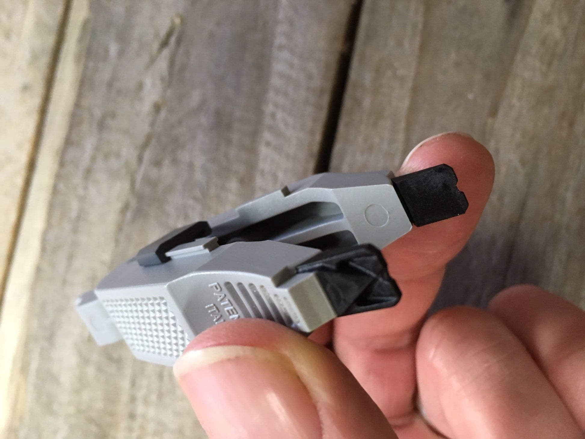 Stonfo fishing shot removal tool held between fingers for easy shot adjustment